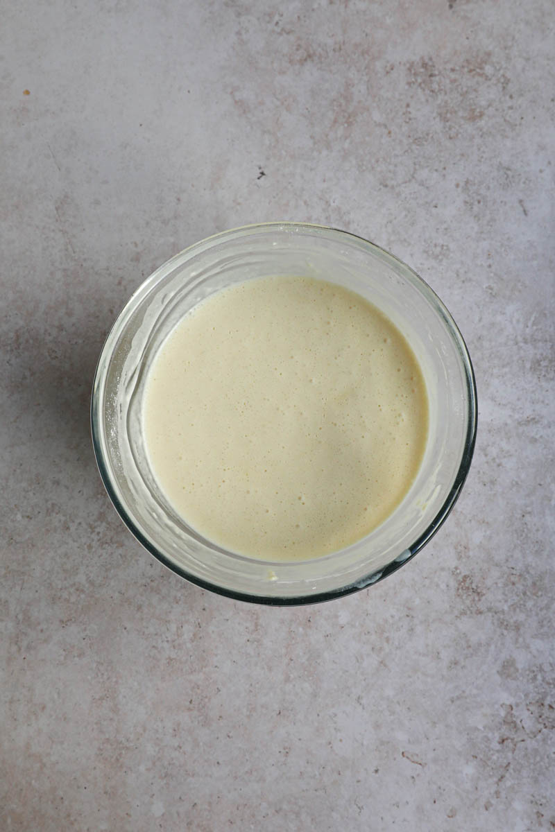 The crepe batter inside a glass bowl, ready to be refrigerated.