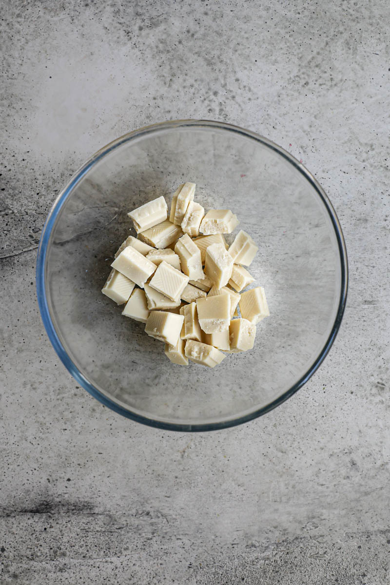 Making the white chocolate ganache cream filling: Chopped white chocolate in a glass bowl.