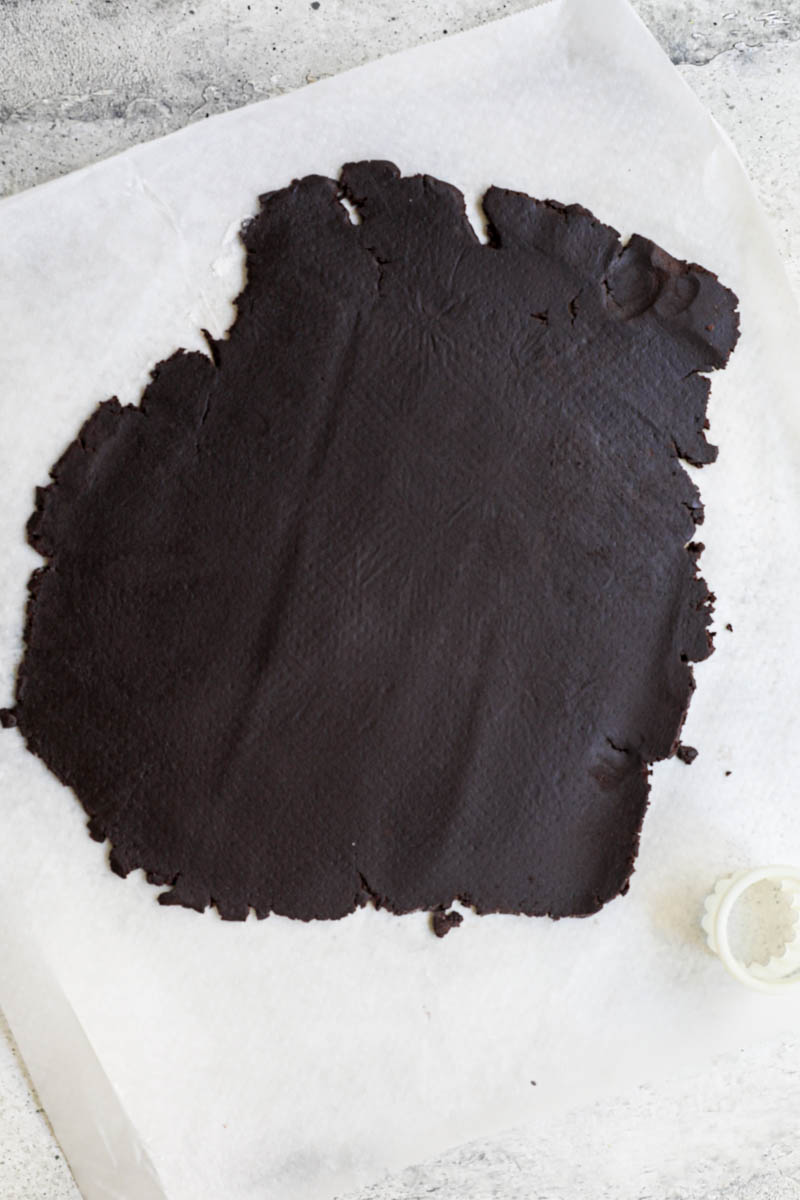 Shape and bake the homemade Oreo cookie: The rolled-out Oreo cookie dough on a piece of parchment paper.
