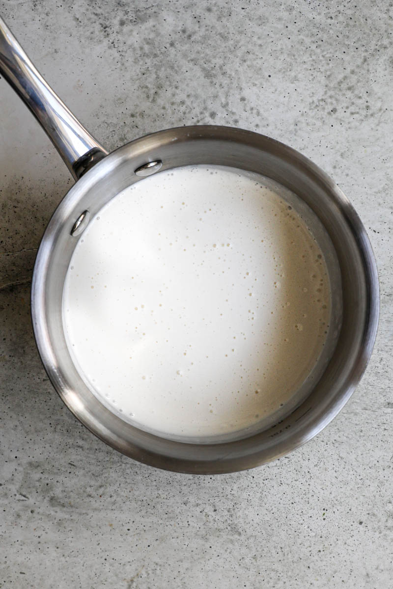 Making the white chocolate ganache cream filling: Heavy cream in a small pan.