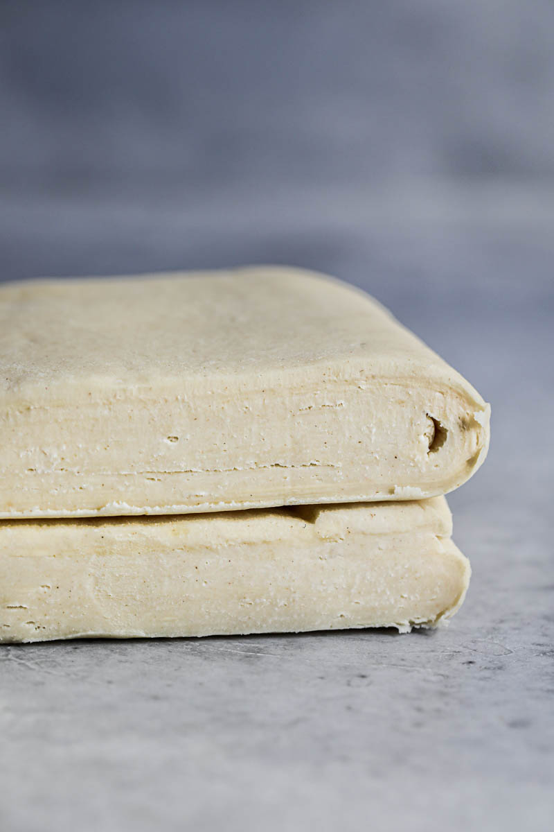 Closeup of the finished rough puff pastry cut in half, one half on top of the other.