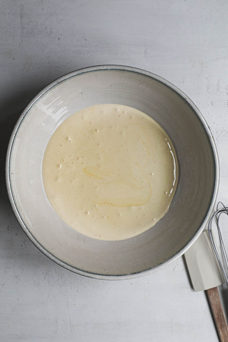 The egg yolks and sugar blanced inside a bowl.