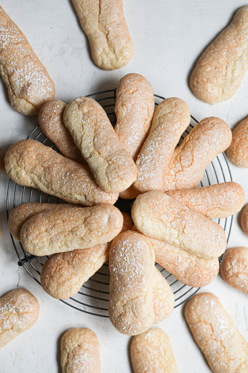 THe ladyfingers cookies placed on top of a wire rack in a circular manner.