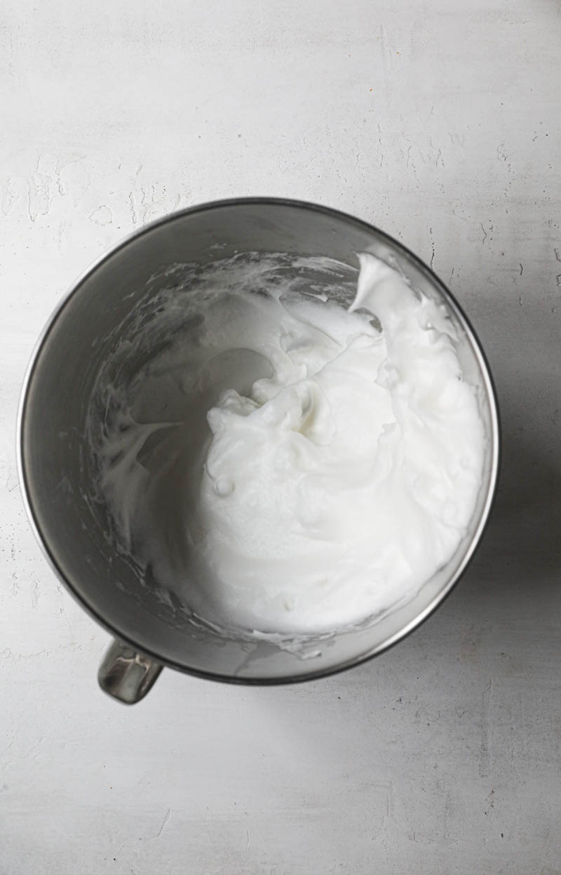 THe egg whites beaten to soft peaks inside the mixing bowl.