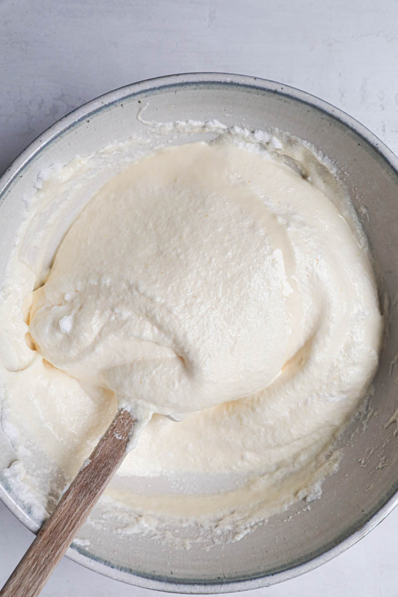 The ladyfingers cookies batter before addding in the flour with a spatula inisde the bowl.