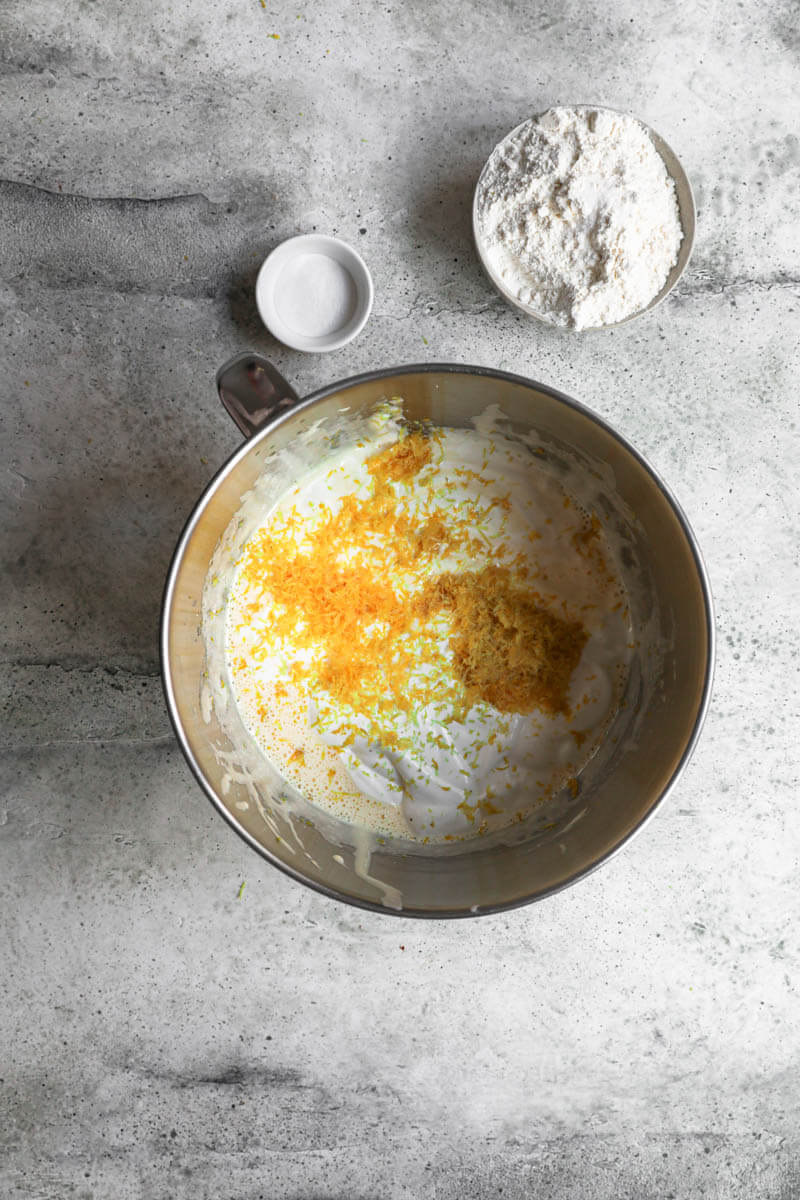 Overhead shot of the mixing bowl with the batter plus whipped cream and lemon zest