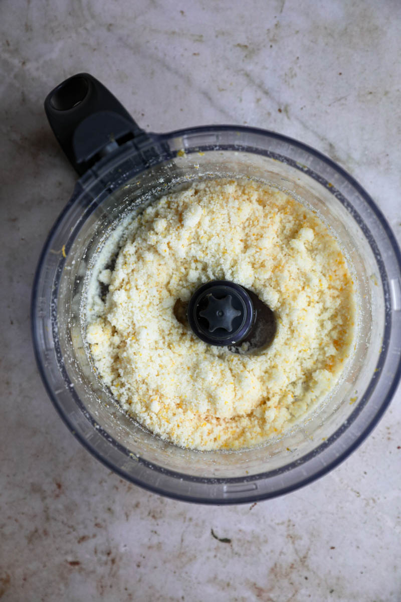 Sugar and lemon zest in the bowl of the food processor.