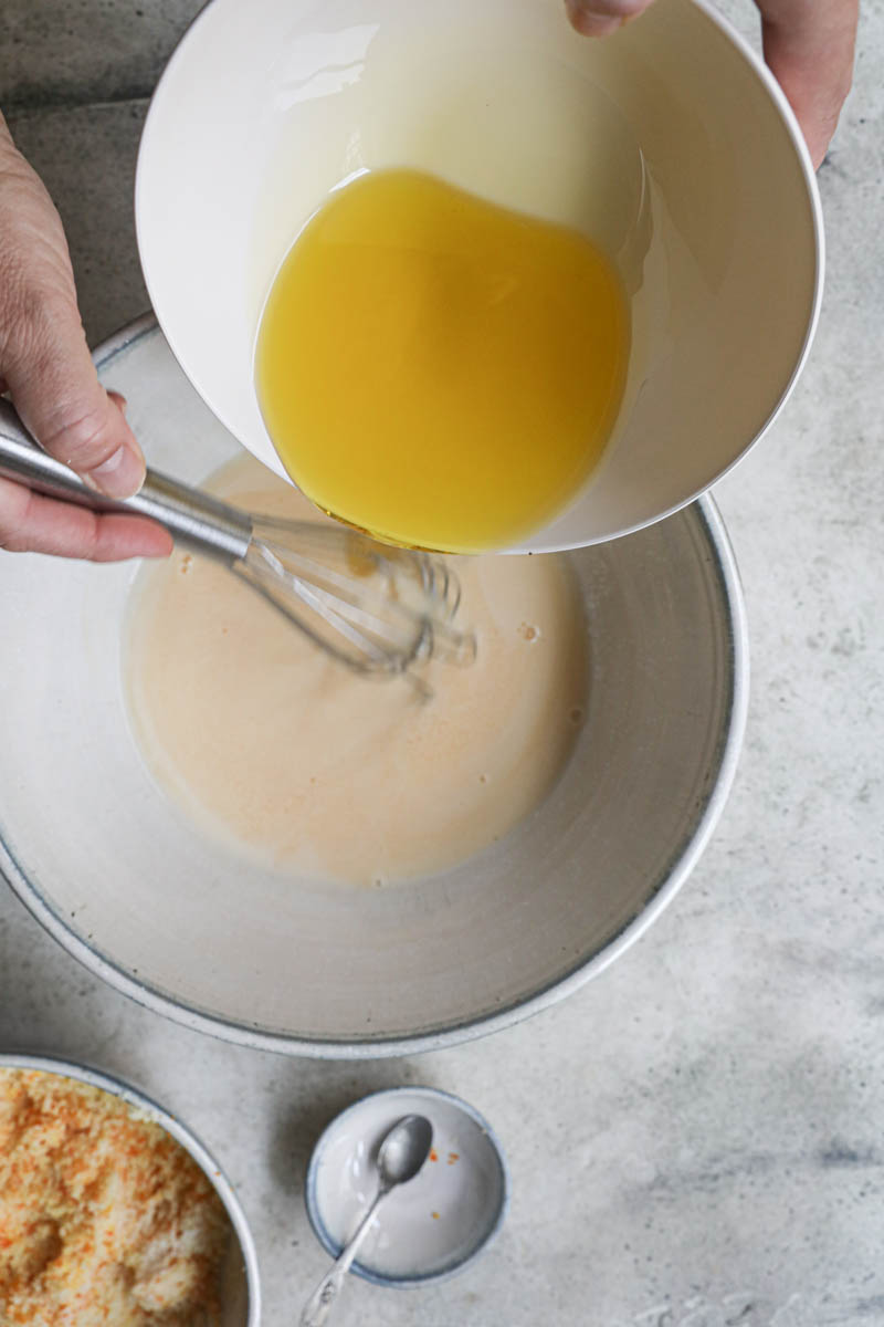 One hand whisking in the olive oil into the mandarin cake batter.