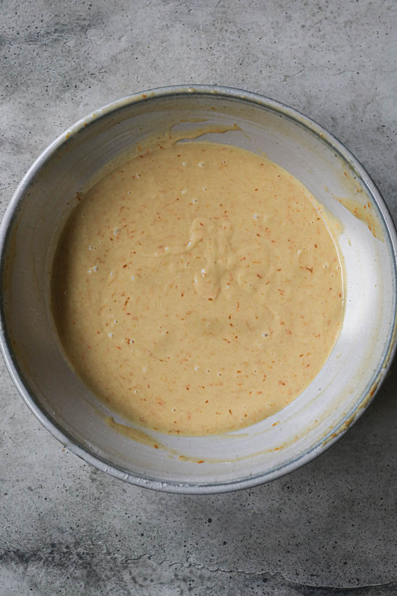 The mandarin orange cake batter ready inside a grey bowl.