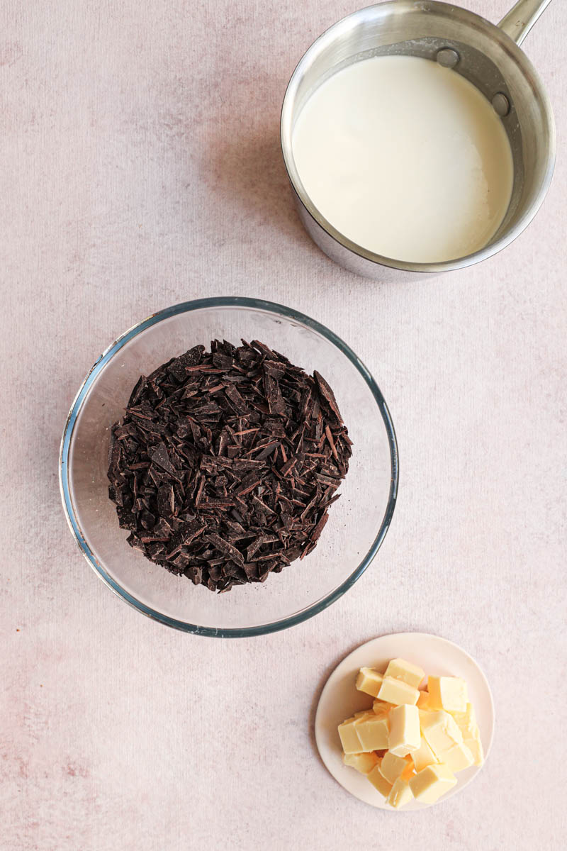 Ingredients for the chocolate ganache: chopped dark chocolate, heavy cream and butter.