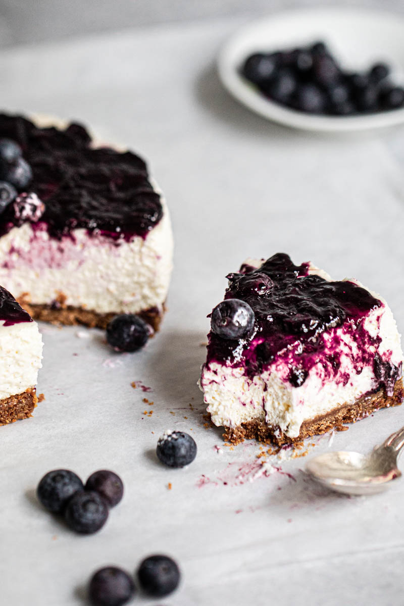 One slice and the rest of the homemade no bake vanilla blueberry cheesecake on the side.