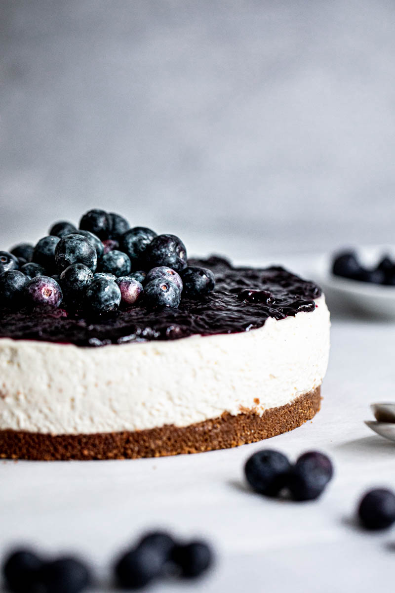 Closeup of the sliced no bake blueberry cheesecake with blueberry topping as seen from the side.