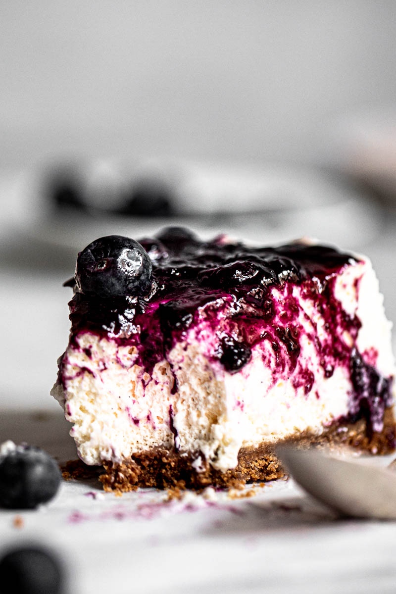 Once slice of no bake vanilla blueberry cheesecake with a spoon on the side.