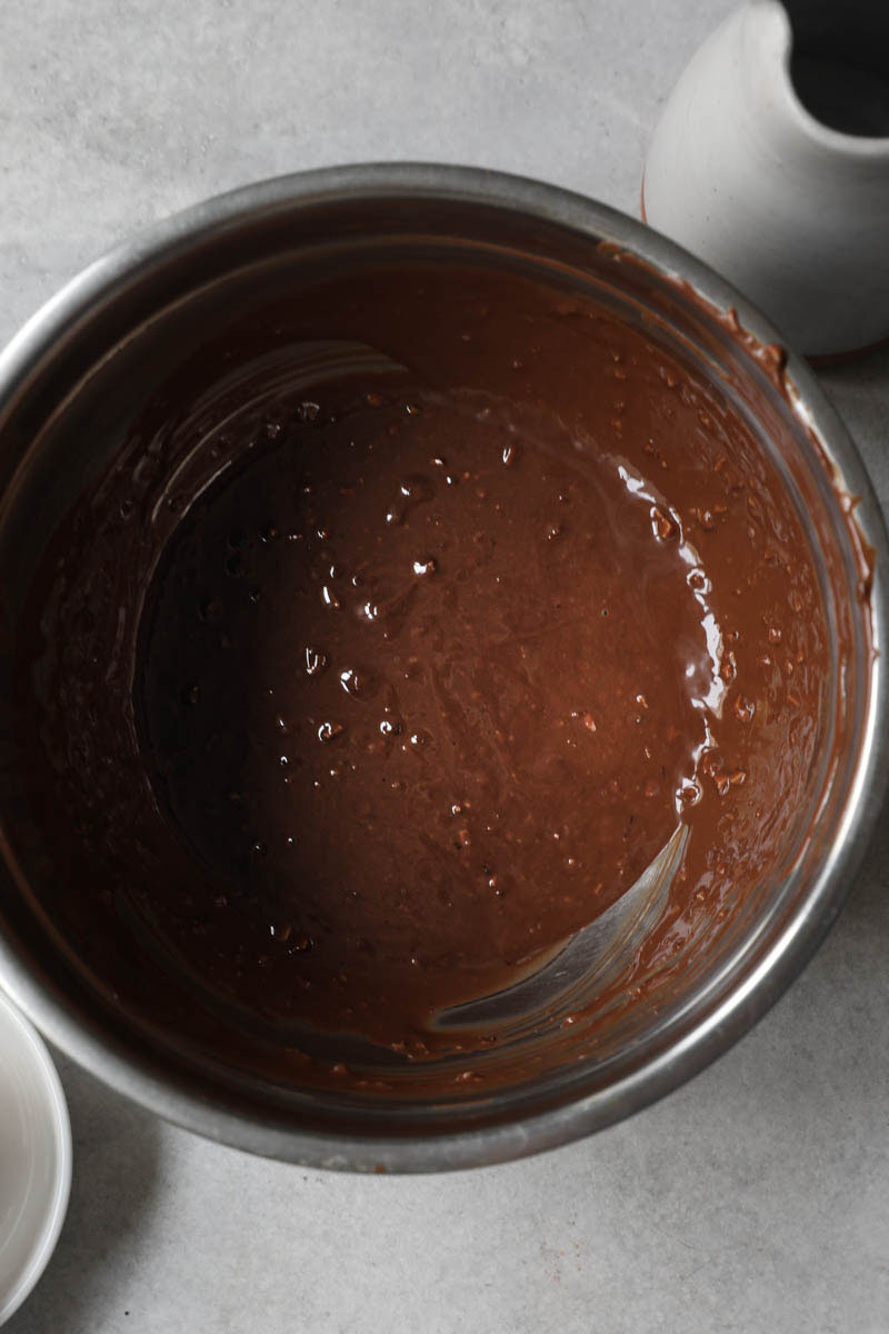 A closeup of the almond chocolate glaze ready to use inside a bowl.
