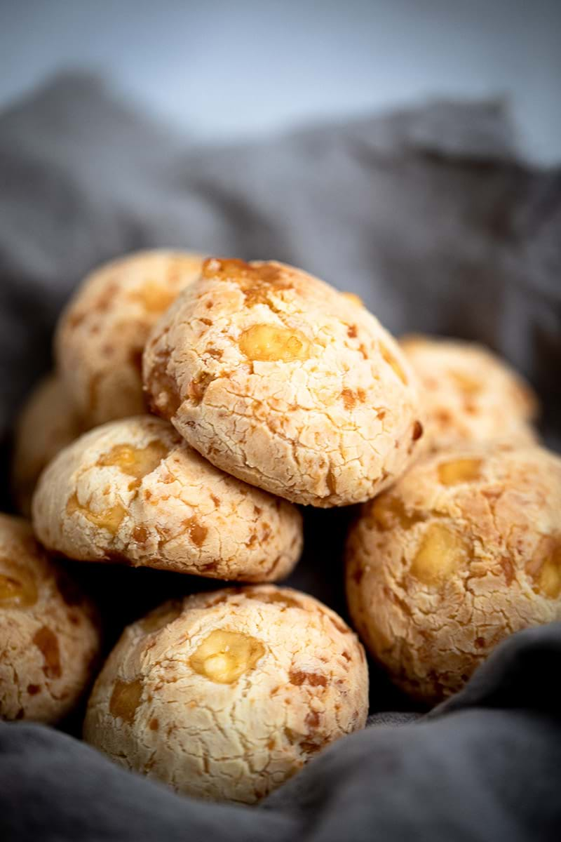 45° shot of pao de queijo in a bowl covered with a linen