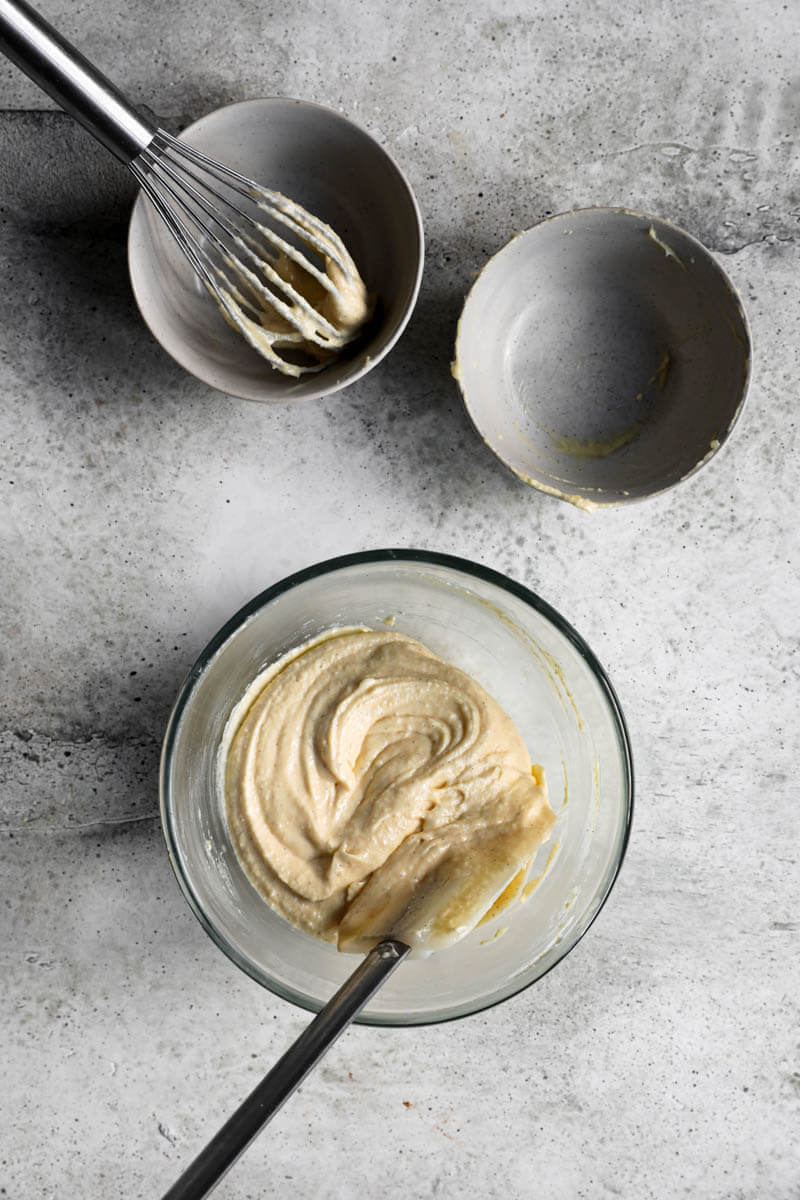 Overhead shot of the frangipane cream in a bowl with 2 empty bowls placed in a triangular form next to it