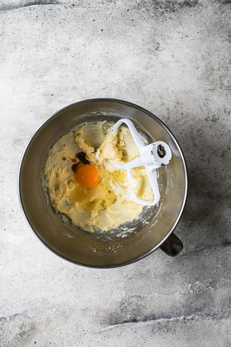 A bowl with softened butter, powdered sugar, egg and vanilla extract