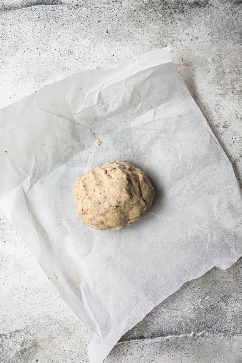 Shortbread cookie dough rolled into a ball on a piece of parchment paper