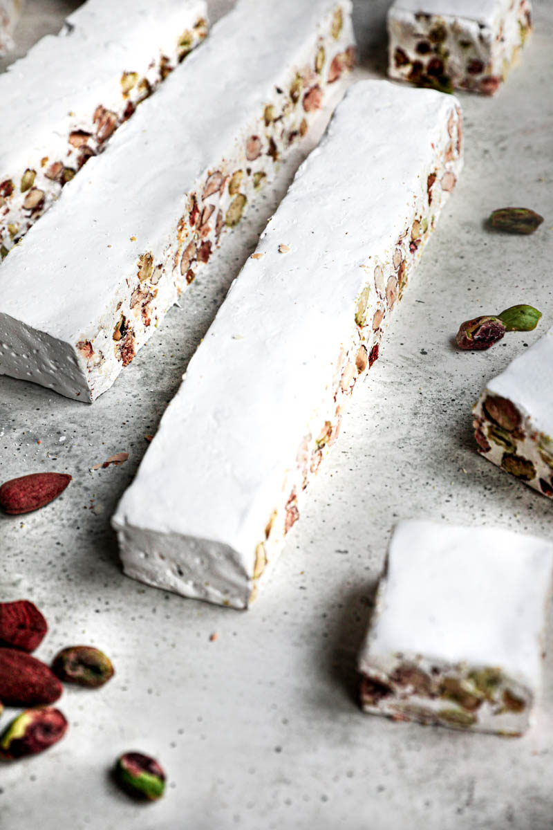 The almond pistachio nougat cut into strips and then into squares.