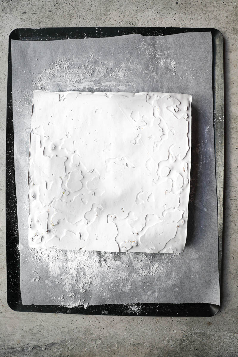 The almond pistachio nougat on a baking tray lined with parchment paper once the cake ring has been removed.