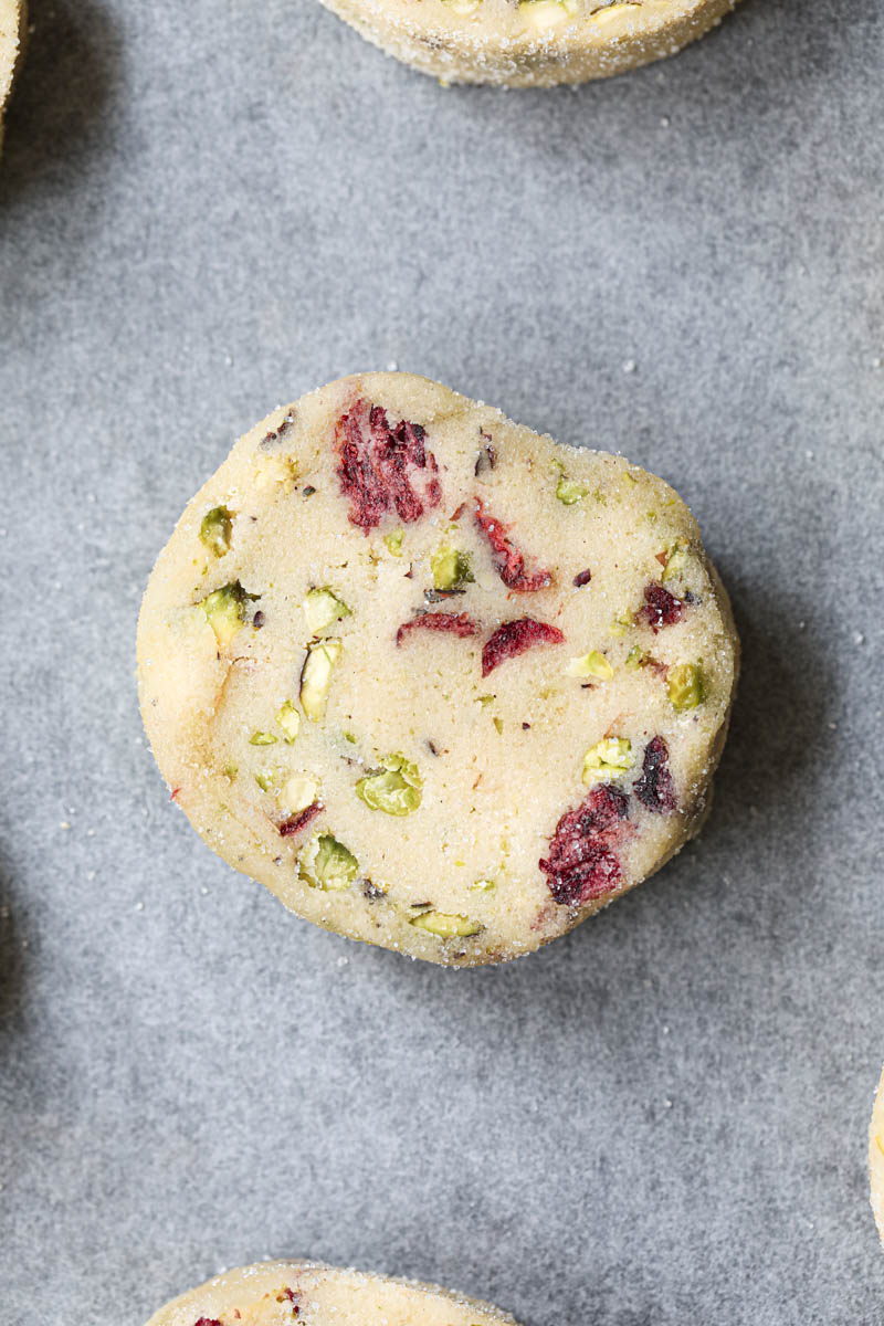 Closeup of one raw cranberry pistachio shortbread cookie.