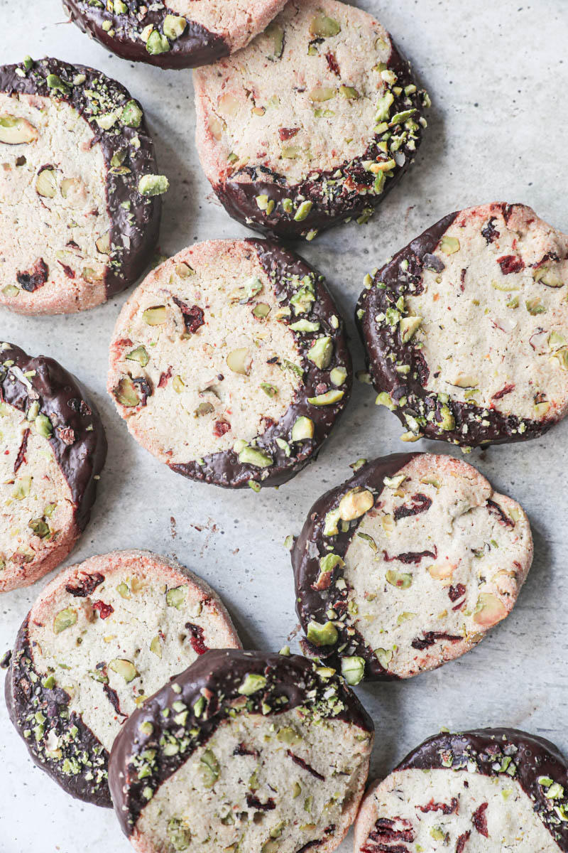 The pistachio cranberry shortbread cookies arranged in an irregular manner as seen from above.