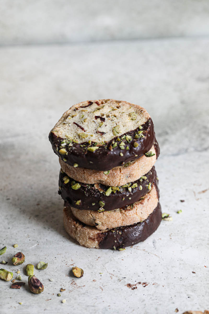 4 stacked cookies dipped in chocolate drizzled with crushed pistachios
