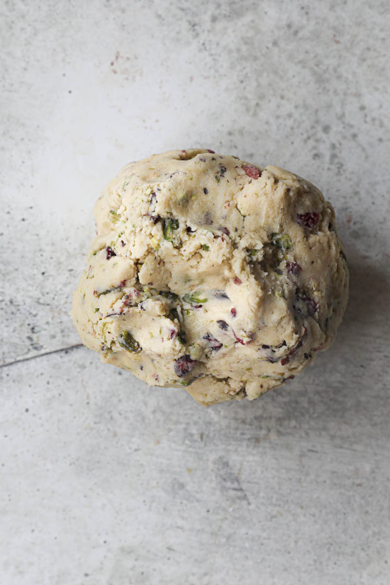 The cranberry pistachio shortbread cookie dough shaped as a ball.