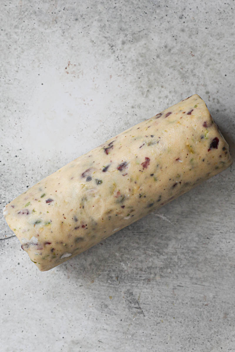 The cranberry pistachio shortbread cookie dough shaped as a log.