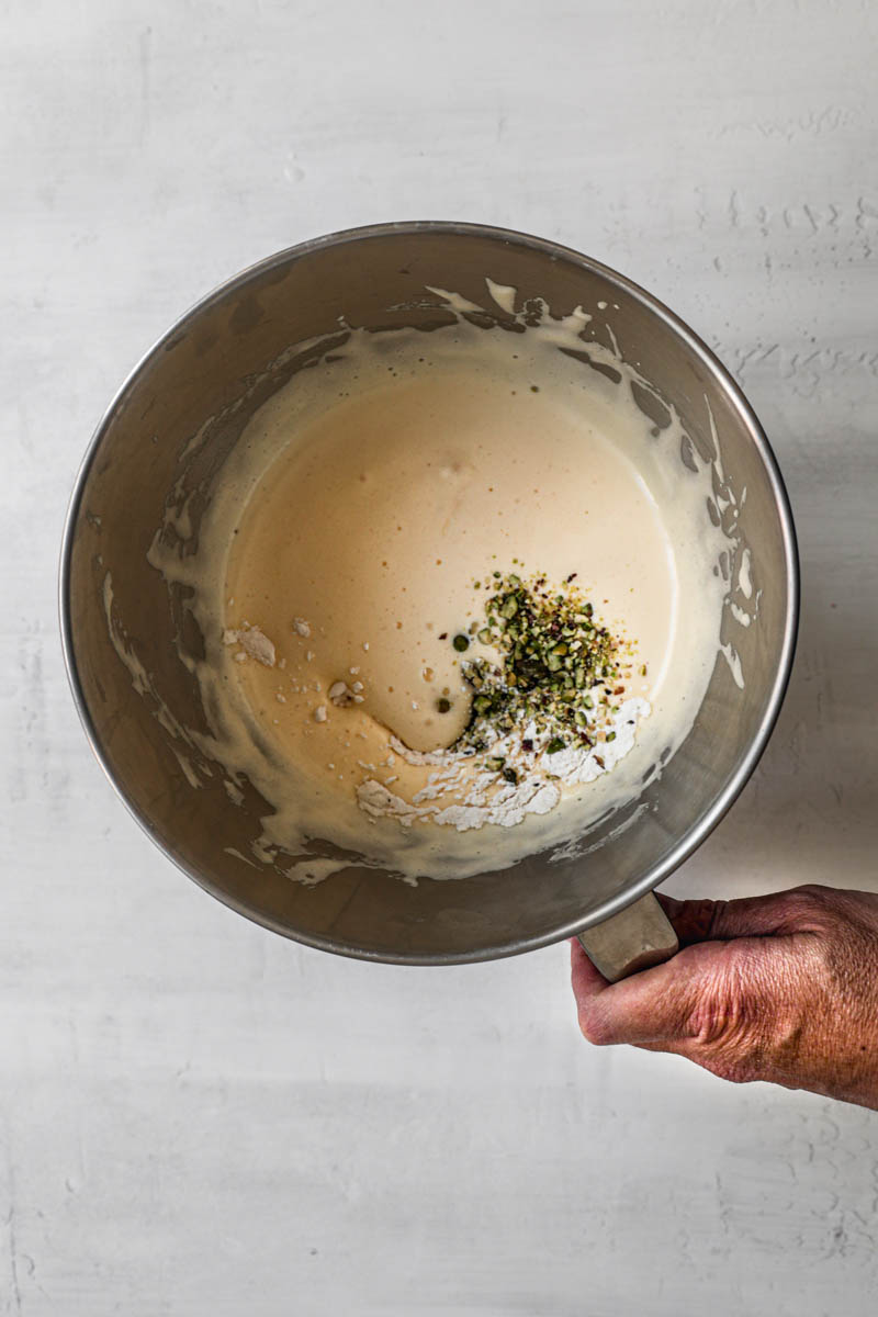A bowl with the blanched eggs and sugar plus the grounded pistachios and the dry ingredients.
