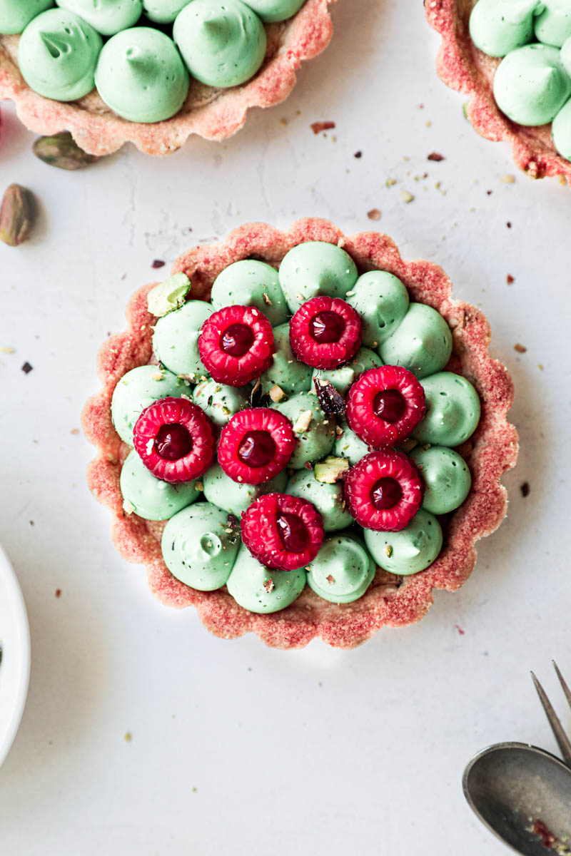 One pistachio raspberry white chocolate tartlet assembled and ready to enjoy.