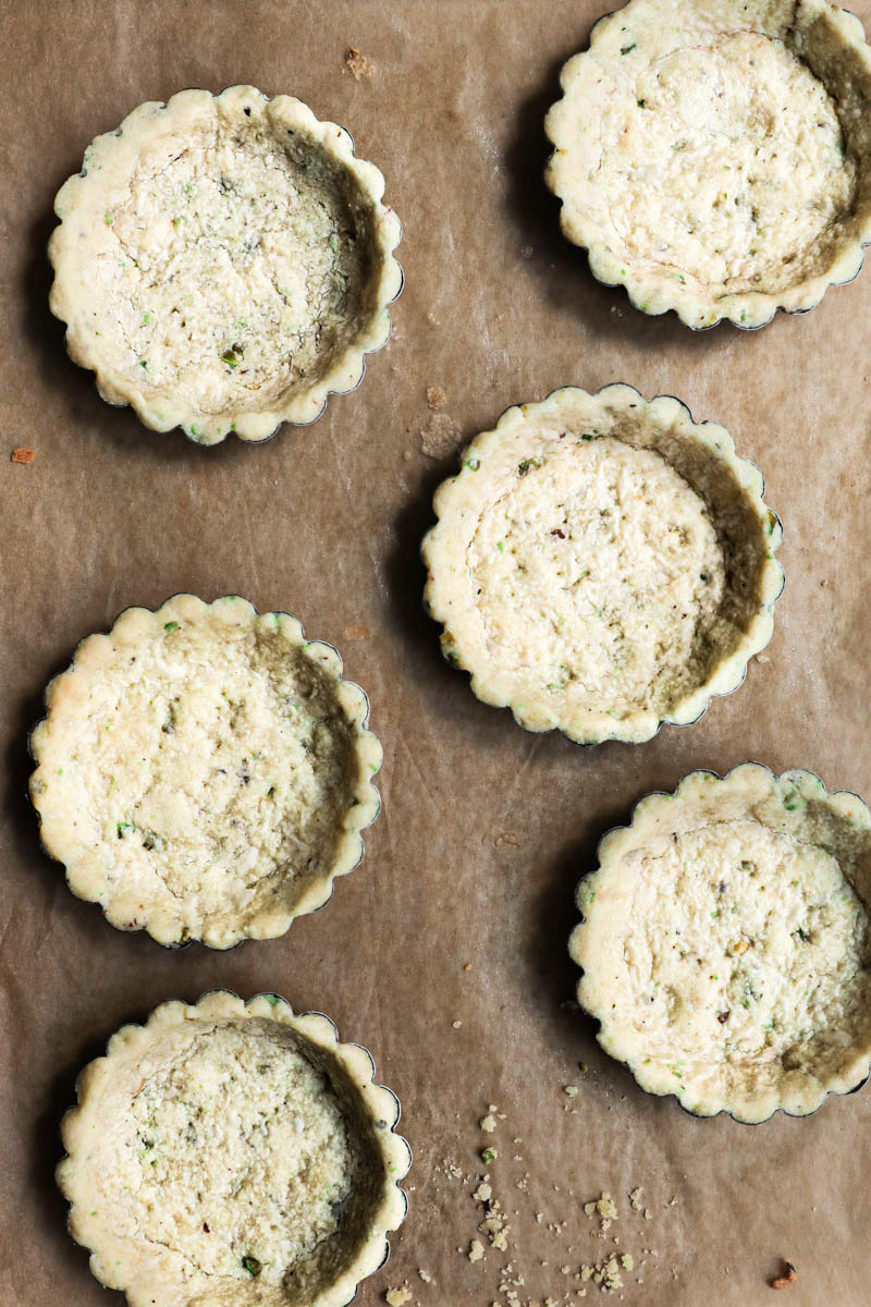 6 tartlets tins with the baked pistachio shortbread crust.