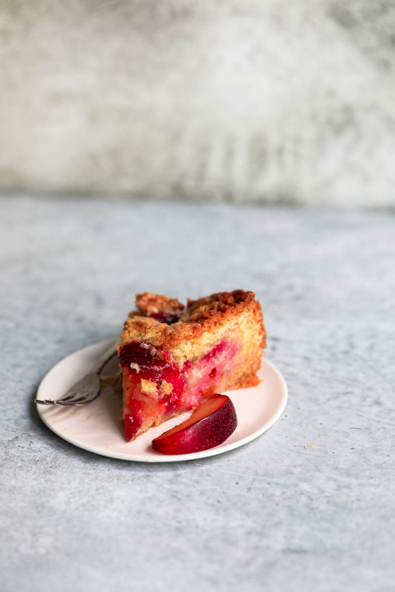 45° shot of a slice of plum cake on a plate