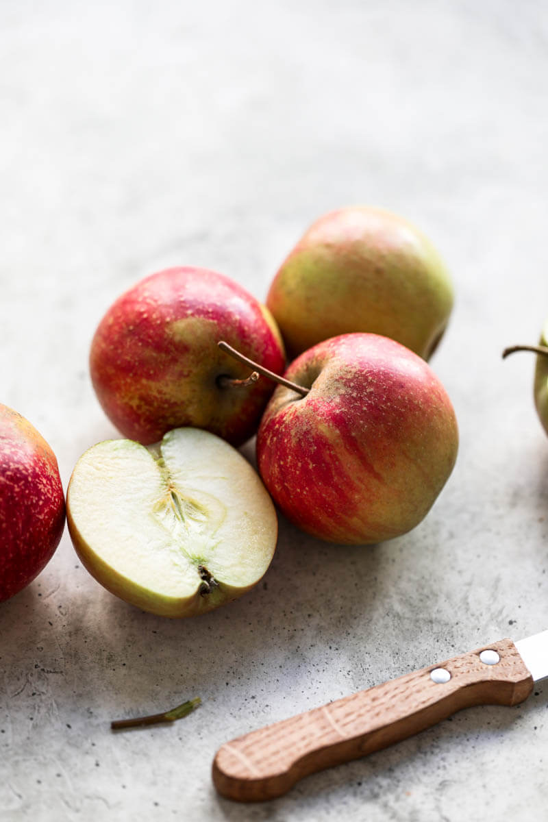 90° shot of red apples with a knife at the bottom right corner