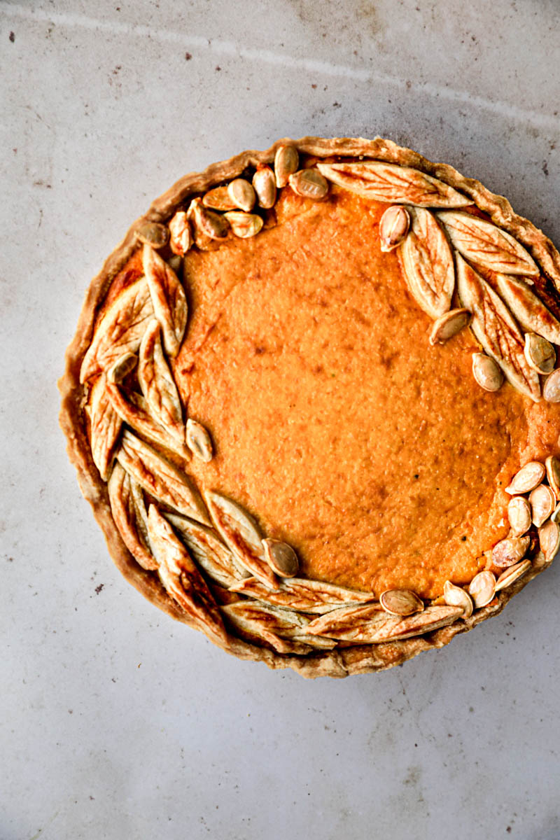 The whole pumpkin ricotta quiche with a pumpkin seen from above slightly towards the left of the frame.