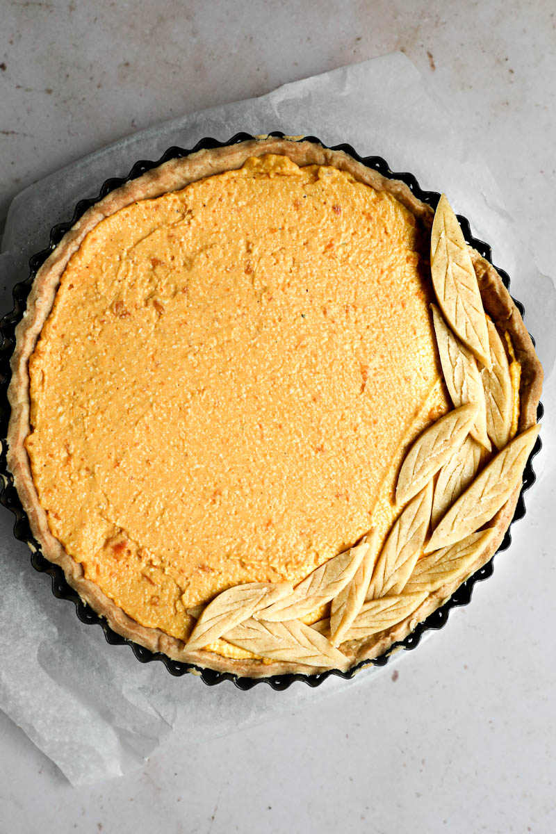 The pumpkin quiche filled and topped with the pastry dough leaves.