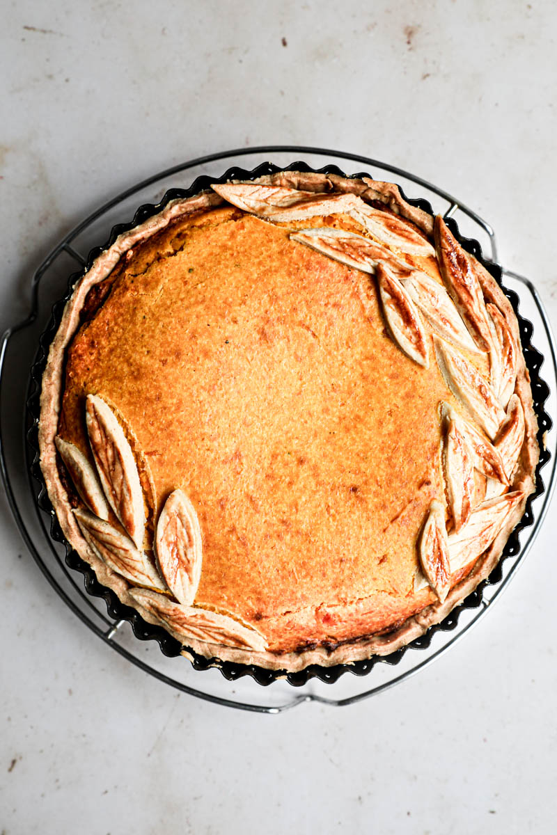 The baked savory pumpkin pie inside the tin placed on wire rack.