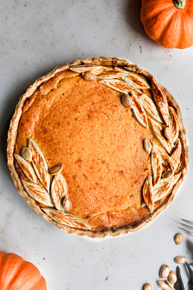 The baked savory pumpkin pie sin from above with some pumpkins around it.