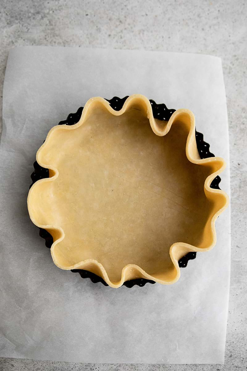 Lining the tart tin with quiche crust