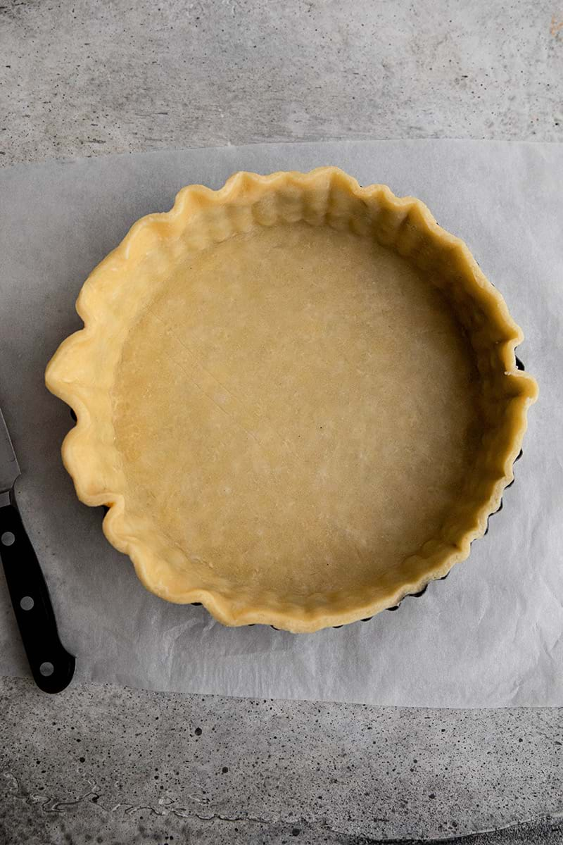 Lining the tart tin with quiche crust