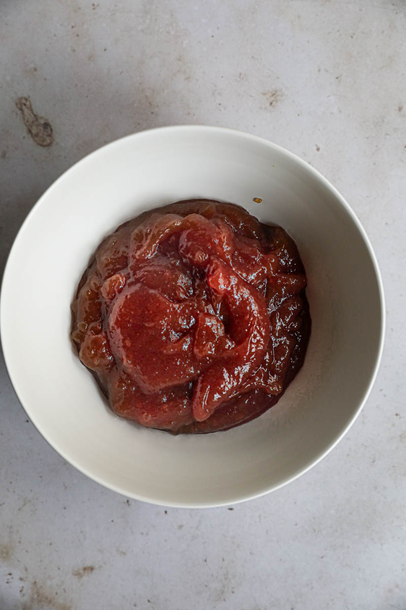 The quince pie filling inside a beige bowl.