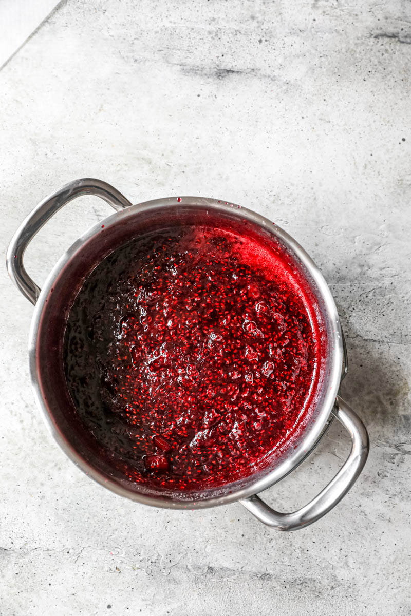 The cooked raspberry jam inside a pot.