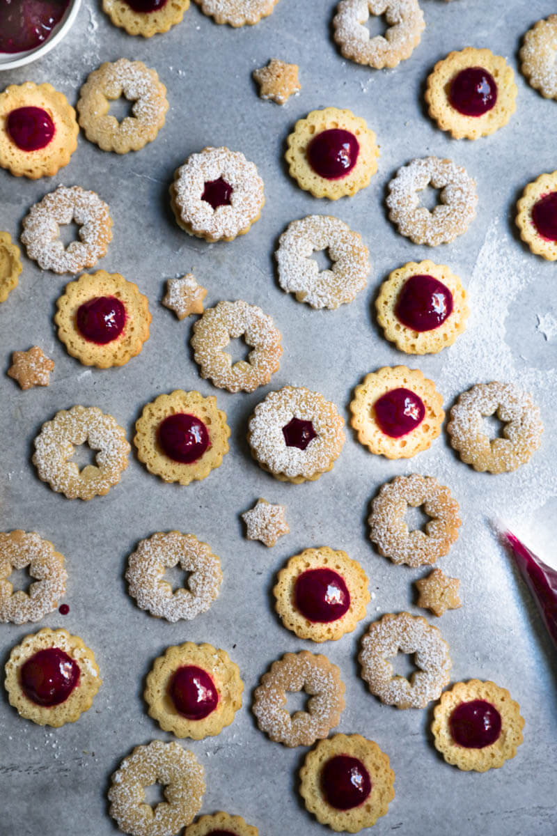 Cookie rounds filled with raspberry jam and cookie tops arranged in an irregular manner