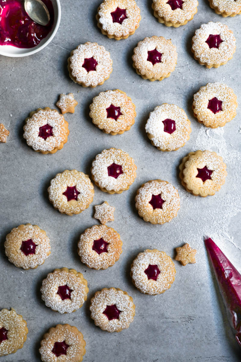 Linzer cookie bottoms filled with raspberry jam toped with the linzer cookie top