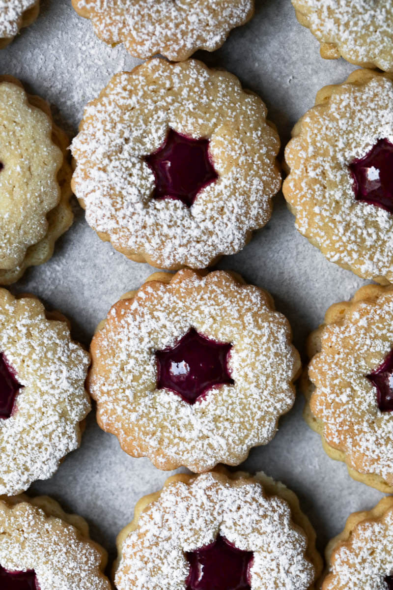 Linzer cookies filled with raspberry jam arranged in lines