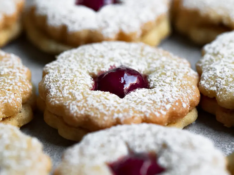 Linzer cookies filled with raspberry jam arranged in lines