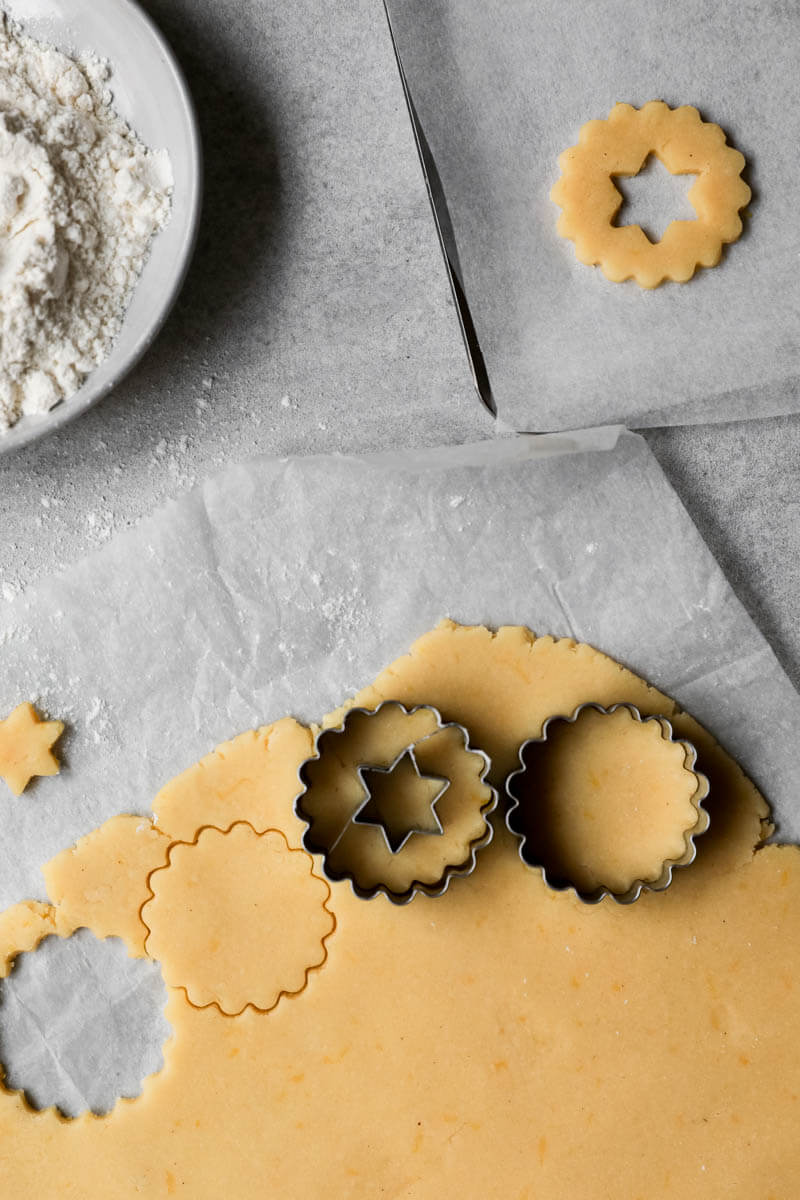 Rolled out linzer cookie dough with cookie cutter on top