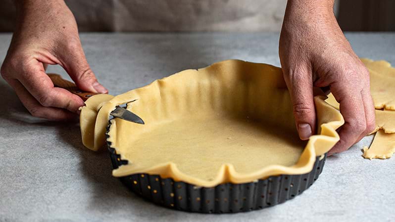 Action shot: lining the tart tin with the shortbread crust