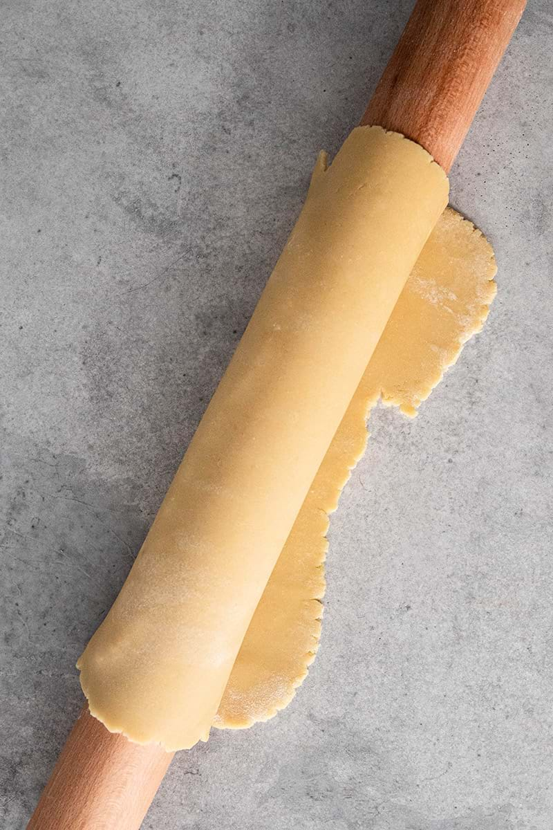 Rolled out shortbread crust rolled around the rolling pin