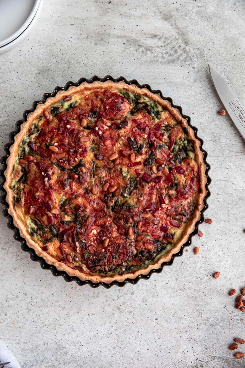 Baked spinach bacon quiche in the quiche tin.